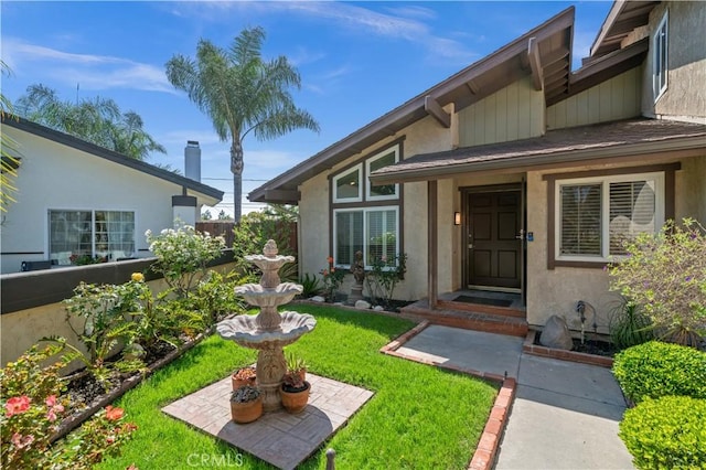 doorway to property with a lawn and stucco siding