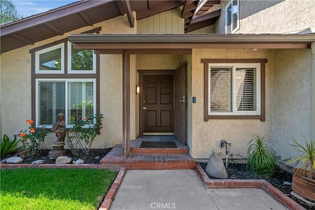 doorway to property featuring stucco siding