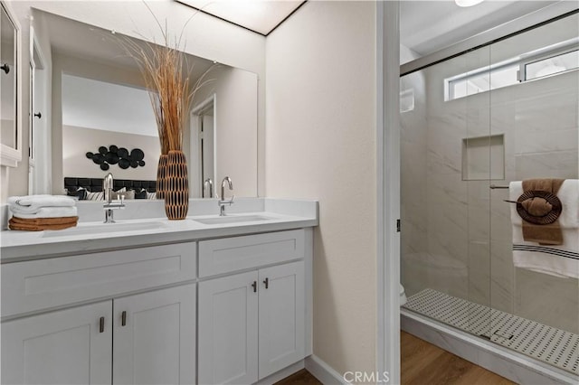 full bathroom featuring a sink, double vanity, toilet, and a shower stall