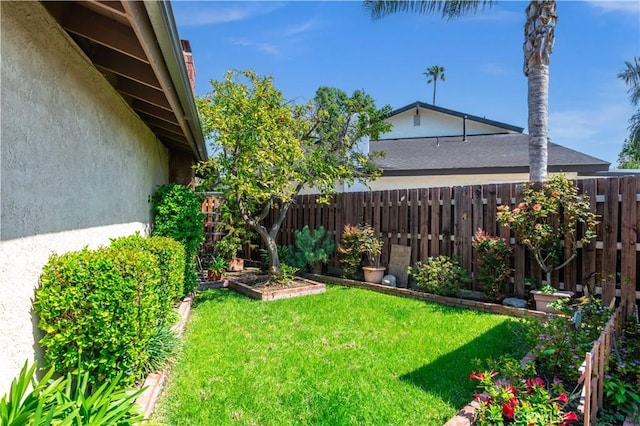 view of yard featuring fence and a vegetable garden