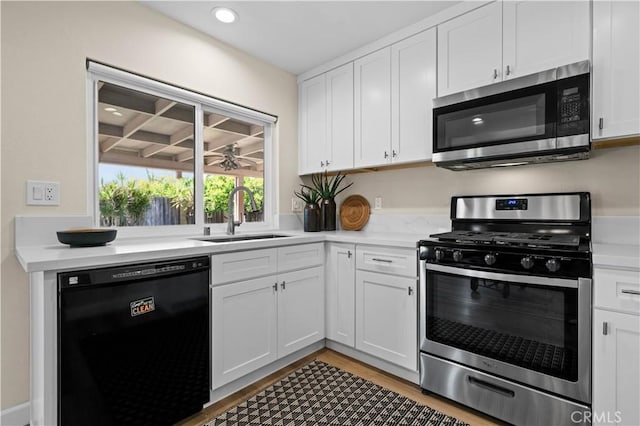 kitchen featuring a sink, stainless steel appliances, light countertops, and white cabinets