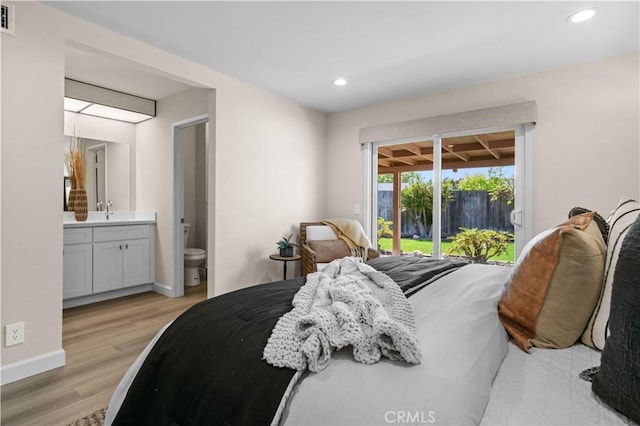 bedroom featuring recessed lighting, baseboards, a sink, light wood-style floors, and access to exterior