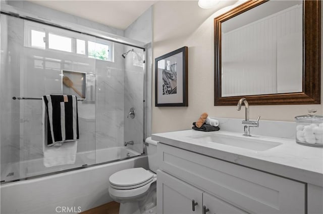 full bath featuring toilet, vanity, and shower / bath combination with glass door