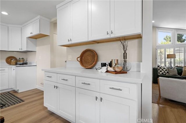 kitchen featuring open floor plan, white cabinetry, light countertops, light wood-style floors, and recessed lighting