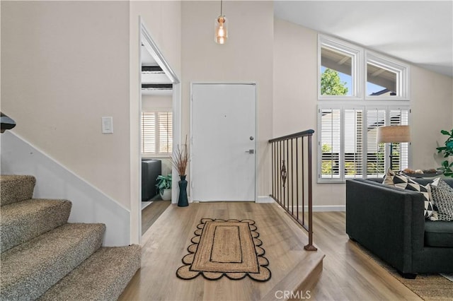 entryway with baseboards, stairs, and wood finished floors