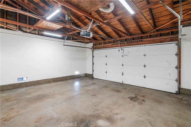 garage with baseboards and a garage door opener