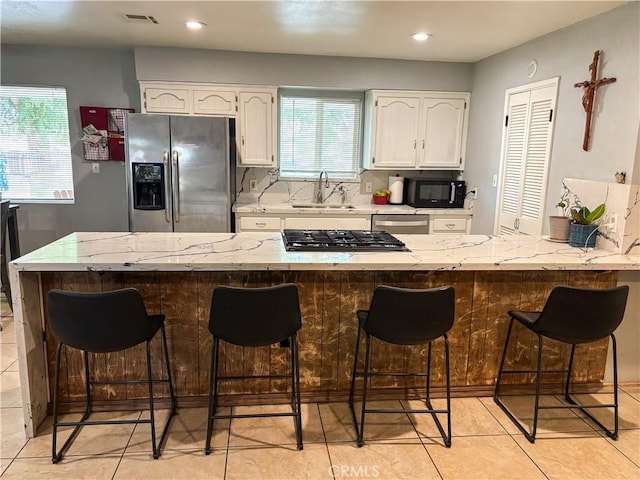 644 Whittendale St, Bakersfield, CA 93307 - kitchen with a sink, stainless steel appliances, white cabinets, plenty of natural light, and visible vents