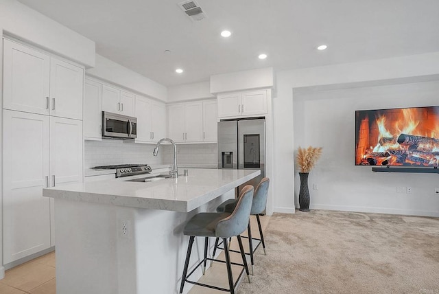 2152 Reed Dr, San Diego, CA 92154 - kitchen with a sink, stainless steel appliances, white cabinets, visible vents, and tasteful backsplash