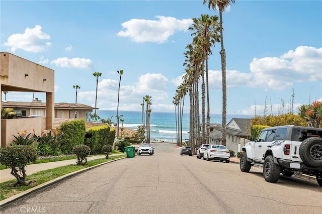 view of road featuring a water view and sidewalks