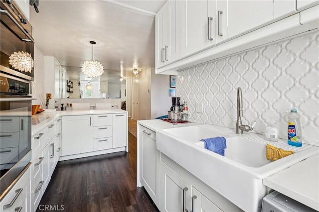 kitchen with decorative light fixtures, dark wood finished floors, white cabinetry, light countertops, and oven