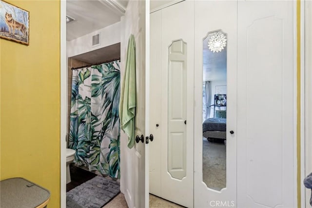 full bathroom featuring toilet, visible vents, and curtained shower
