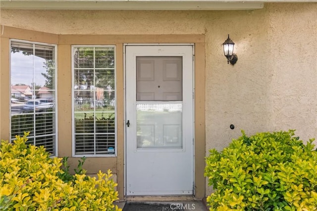 doorway to property featuring stucco siding
