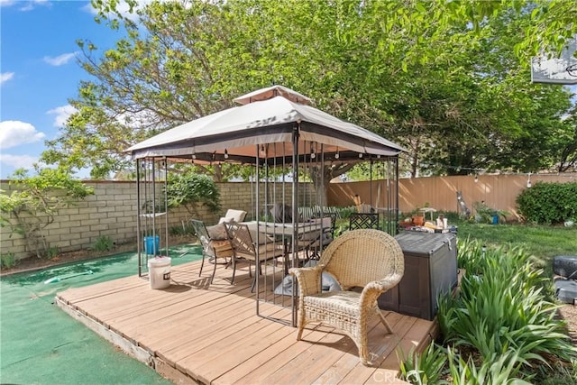 deck with a fenced backyard, a gazebo, and outdoor dining space