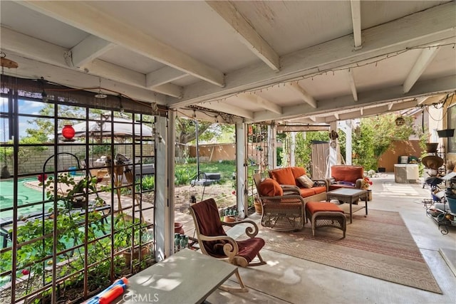 sunroom featuring unfinished concrete floors, plenty of natural light, and beam ceiling