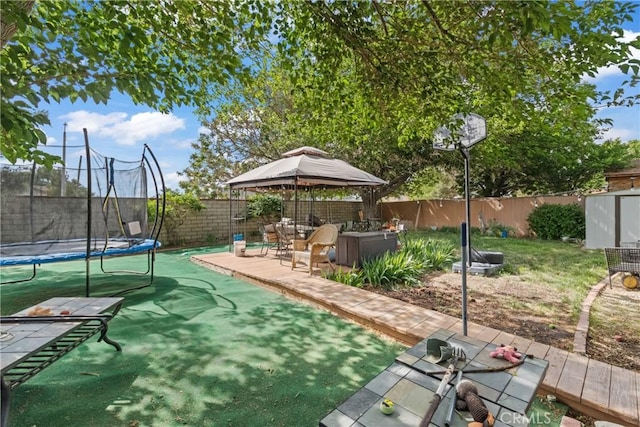 view of yard featuring a patio, a storage unit, a trampoline, a gazebo, and a fenced backyard