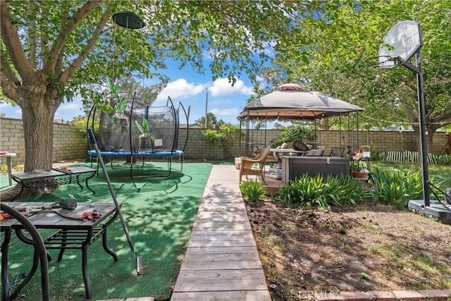 view of property's community featuring a fenced backyard, a gazebo, and a trampoline