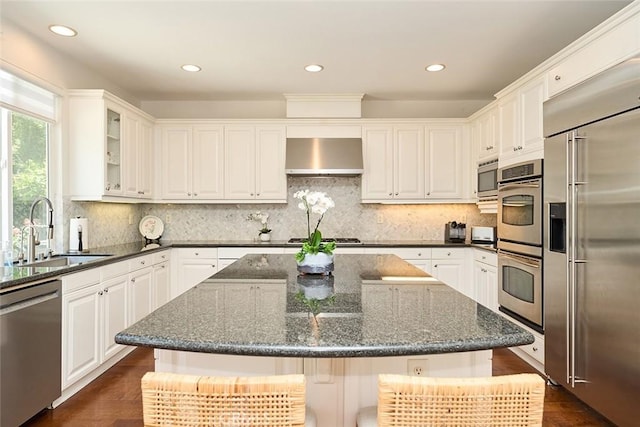 1472 Nicolas Way, Fullerton, CA 92833 - kitchen featuring built in appliances, a sink, wall chimney range hood, glass insert cabinets, and white cabinetry