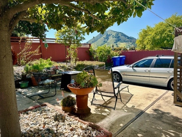 view of patio / terrace featuring a mountain view and fence