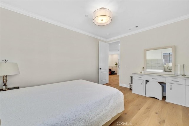 bedroom featuring light wood finished floors, crown molding, baseboards, and visible vents