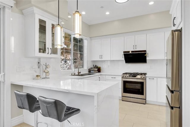 kitchen with glass insert cabinets, a sink, white cabinetry, a peninsula, and appliances with stainless steel finishes