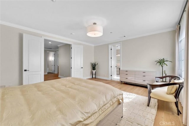 bedroom with ensuite bath, crown molding, baseboards, and light wood-type flooring