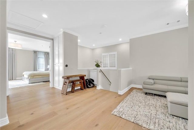 living room featuring recessed lighting, attic access, baseboards, ornamental molding, and light wood-type flooring