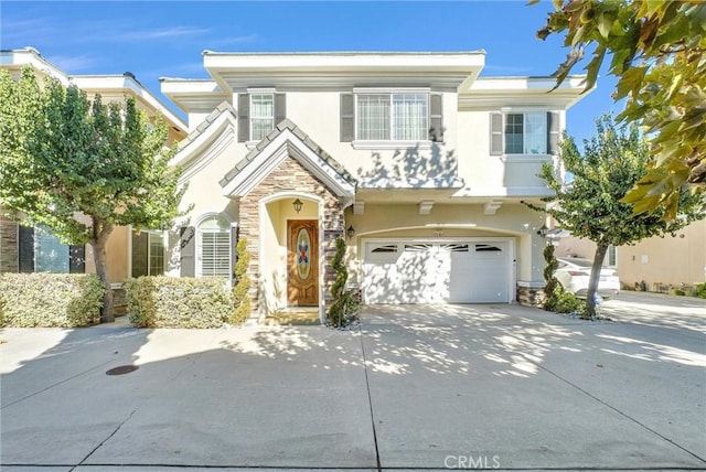 traditional-style house with an attached garage, stucco siding, stone siding, and driveway