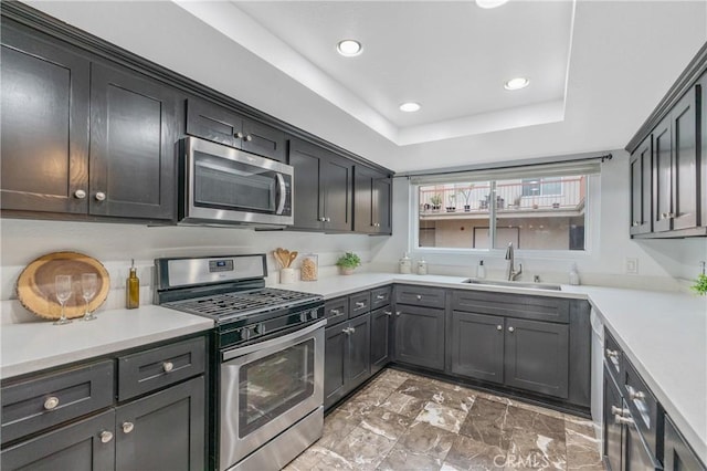 kitchen with a sink, stainless steel appliances, light countertops, marble finish floor, and recessed lighting