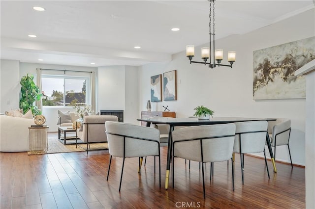 dining space featuring a chandelier, recessed lighting, and wood finished floors