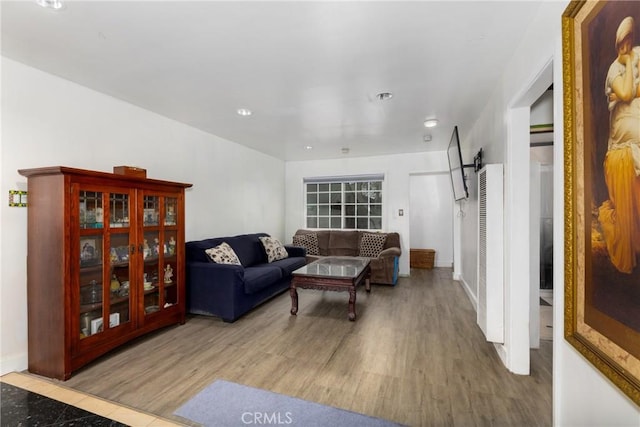 living room with a barn door, wood finished floors, baseboards, and recessed lighting