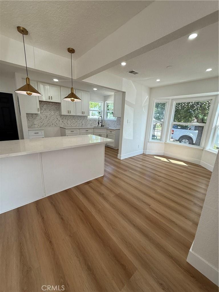 kitchen featuring backsplash, baseboards, a sink, and wood finished floors