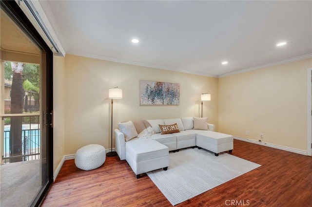 living room featuring wood finished floors, baseboards, ornamental molding, and recessed lighting