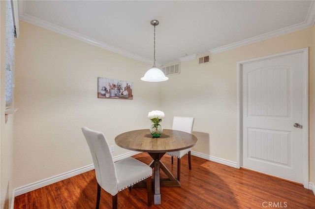 dining area with ornamental molding, visible vents, and wood finished floors
