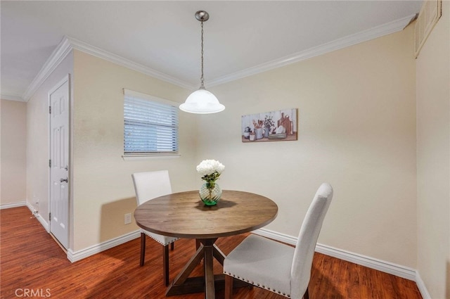 dining space featuring wood finished floors, baseboards, and ornamental molding