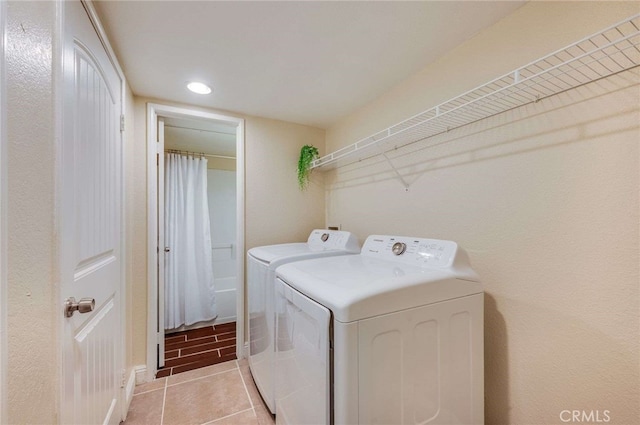 clothes washing area featuring laundry area, washer and clothes dryer, light tile patterned floors, and recessed lighting