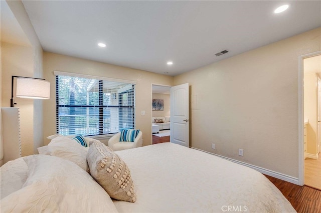 bedroom with recessed lighting, baseboards, visible vents, and wood finished floors