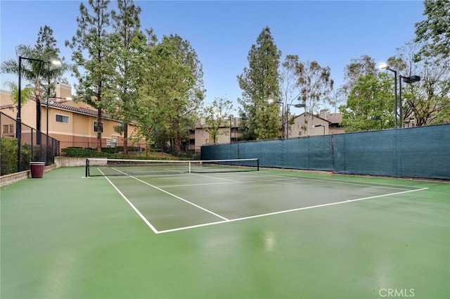 view of tennis court featuring fence and community basketball court