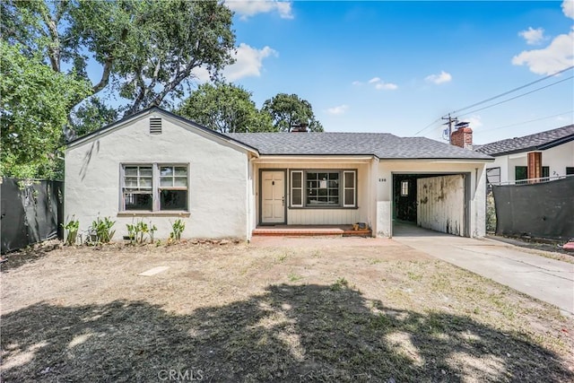 view of front of home featuring a porch, fence, an attached garage, concrete driveway, and stucco siding