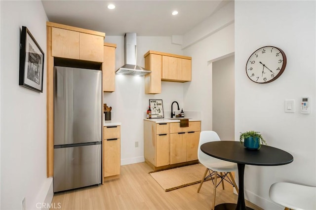 3130 Kallin Ave, Long Beach, CA 90808 - kitchen with freestanding refrigerator, light brown cabinetry, wall chimney range hood, light wood-style floors, and light countertops