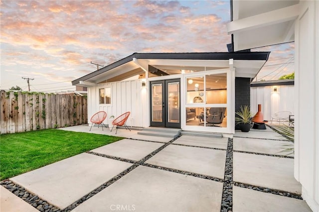 3130 Kallin Ave, Long Beach, CA 90808 - back of house at dusk featuring board and batten siding, a patio area, and french doors