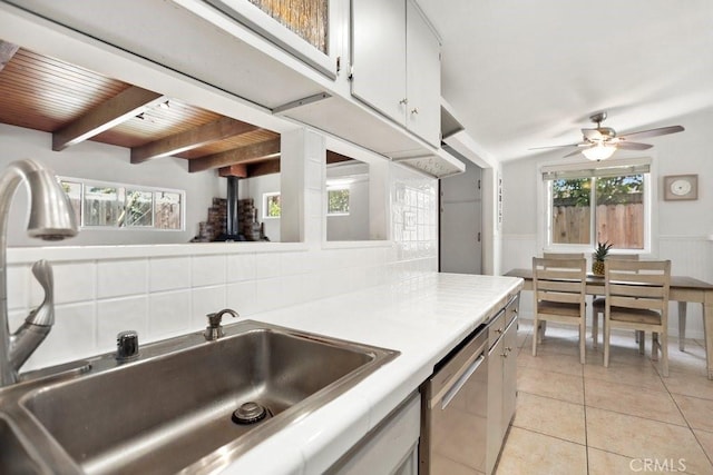 1229 Kilson Dr, Santa Ana, CA 92707 - kitchen with dishwasher, ceiling fan, light tile patterned floors, a wainscoted wall, and tasteful backsplash