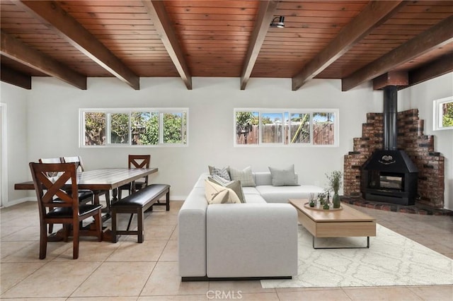 1229 Kilson Dr, Santa Ana, CA 92707 - living area featuring light tile patterned floors, a wood stove, wooden ceiling with exposed beams, and baseboards