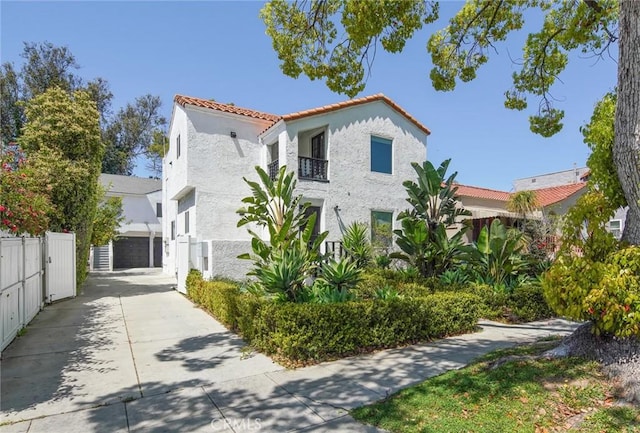 1271 S Sycamore Ave, Los Angeles, CA 90019 - view of property exterior featuring a tile roof, fence, stucco siding, and a balcony
