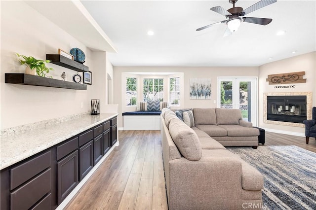 living room featuring plenty of natural light, light wood-style floors, recessed lighting, and baseboards