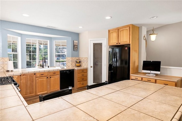 kitchen featuring black appliances, a sink, tile countertops, decorative backsplash, and recessed lighting