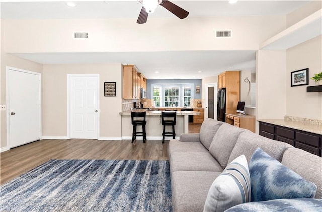 living room with dark wood-style flooring, ceiling fan, and recessed lighting
