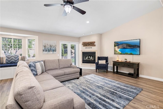 living room featuring wood finished floors, a ceiling fan, recessed lighting, baseboards, and a glass covered fireplace