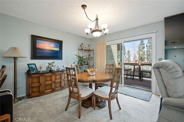 dining room with a textured ceiling, light carpet, visible vents, and a notable chandelier