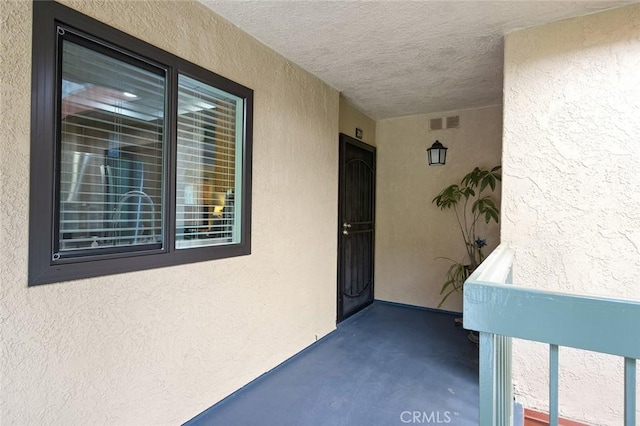 entrance to property with stucco siding and visible vents