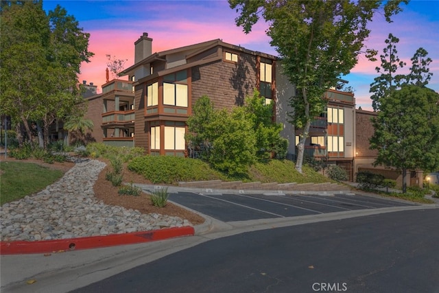 property at dusk with uncovered parking